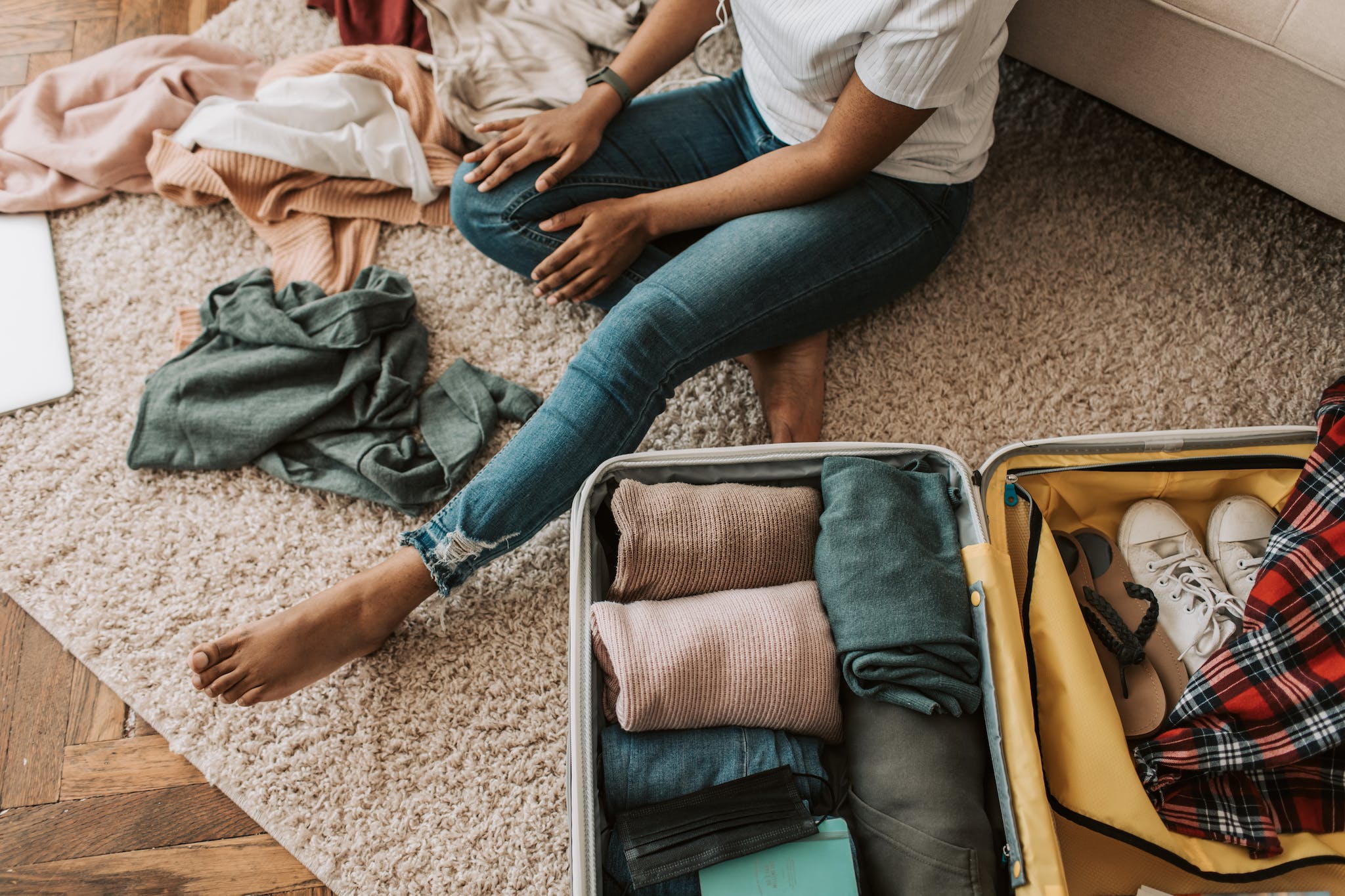 A Woman Packing Her Suitcase - Moving Abroad Packing List