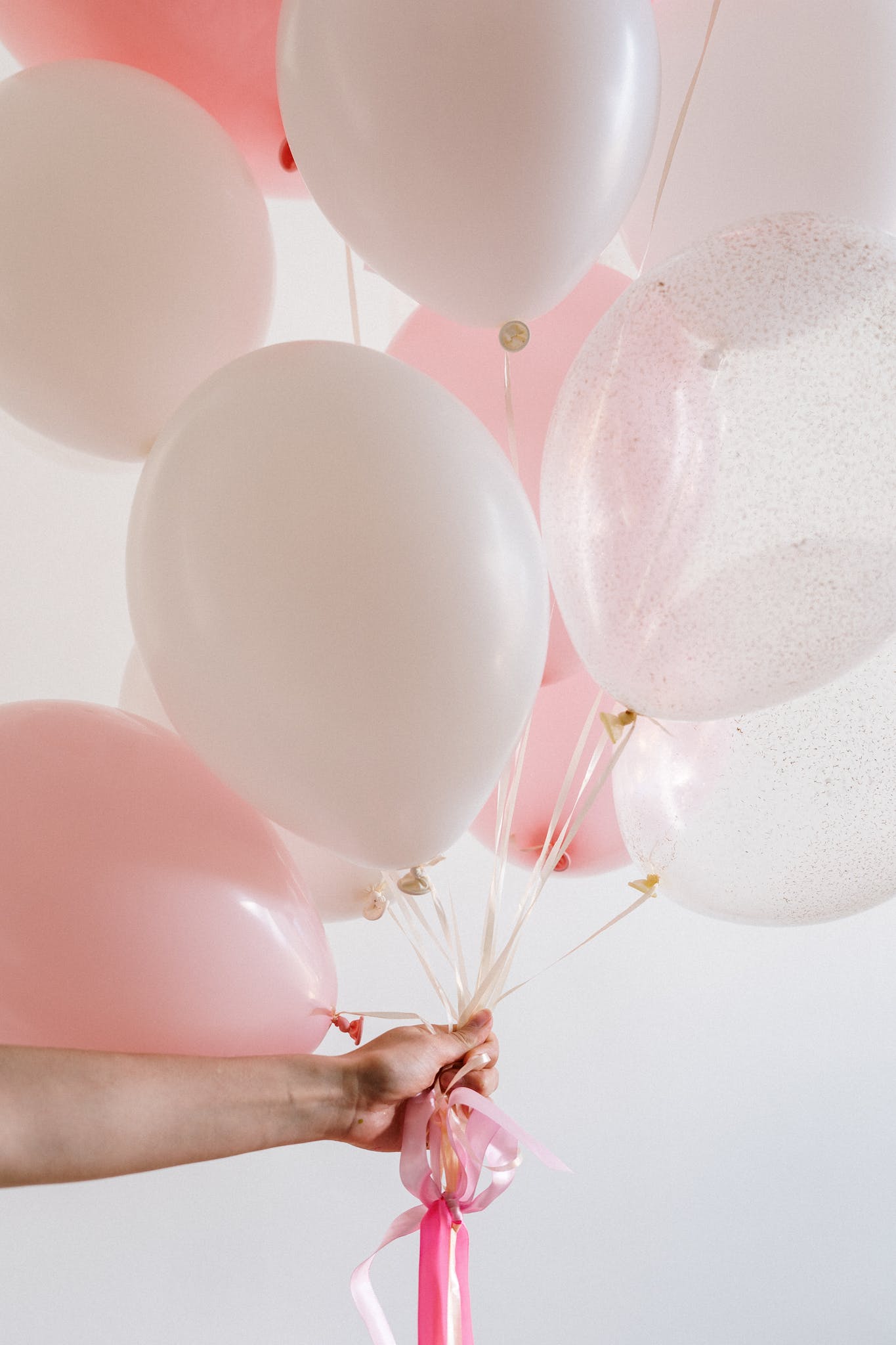 Bouquet of Pink Balloons held by a Person. Happy Birthday in Swedish featured image.